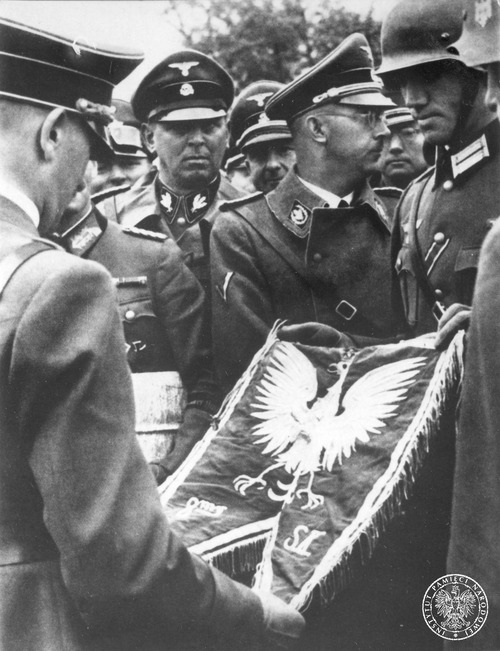 Heinrich Himmler (stoi pośrodku, z głową zwróconą bokiem) w towarzystwie Adolfa Hitlera (odwrócony) ze zdobytym płomieniem trąbki sygnałowej polskiego pułku strzelców konnych, wrzesień 1939 r. (fot. z zasobu IPN, ze zbiorów b. Głównej Komisji Badania Zbrodni przeciwko Narodowi Polskiemu)