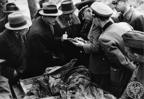 Na stole leżą zwłoki ofiary mordu katyńskiego. Komisja ekshumacyjna przegląda dokumenty znalezione przy ciele ofiary - kwiecień 1943 r. Fot. AIPN