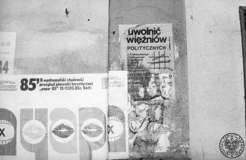 Na zdjęciu po prawej stronie widać przyklejony do muru częściowo zniszczony plakat wzywający do uwolnienia więźniów politycznych, m.in. działaczy KPN: Leszka Moczulskiego, Zygmunta Goławskiego, Tadeusza Jandziszaka i Romualda Szeremietiewa. Po lewej plakat reklamujący studencki przegląd piosenki turystycznej, Łódź 1985 r. Fot. AIPN