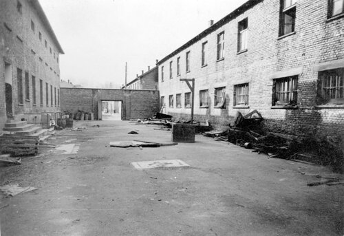 Mur ceglany na dziedzińcu bloku 11;  po prawej przenośna szubienica, 1945 r. Fot. AIPN