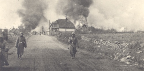 Pacyfikacja Skłobów. Na pierwszym planie maszerujący członkowie SS, w tle palące się budynki. Fot. ze zbiorów Tomasza Kalety