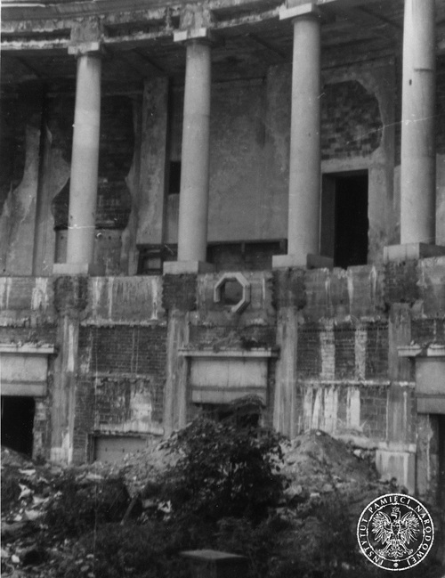 Fragment zniszczeń we wnętrzu gmachu Sejmu, lipiec 1945 r. Widok wnętrza zniszczonego budynku. Zniszczona elewacja, gruz, zarośla porastające zniszczone wnętrze.