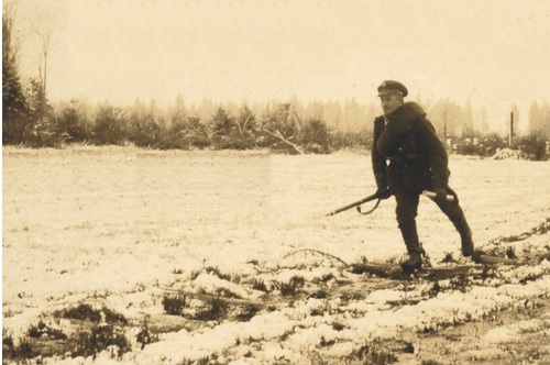 Bieg rozstawny KOP. Żołnierz biegnie po drewnianej kładce położonej na podmokłym terenie, przysypanej pierwszym śniegiem; w tle widoczne słupy na granicy polsko-sowieckiej. Fot. ze zbiorów autora