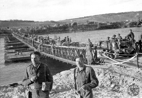 Oficerowie saperów z polskiej 1. Dywizji Pancernej przy moście pontonowym zbudowanym przez ich jednostkę przez rzekę podczas walk na froncie zachodnim we Francji, sierpień - wrzesień 1944 r. Mostem przejeżdża kolumna brytyjskich transporterów gąsienicowych <i>Universal Carrier</i>. W tle kolumna pojazdów wojskowych na drugim brzegu. Po lewej major (może dowódca 10. kompanii saperów mjr sap. Wiktor Neklaws), po prawej porucznik. Fot. z zasobu IPN