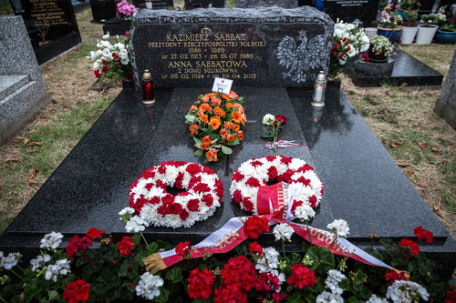 Nagrobek z czarnej płyty, której elementem jest wizerunek Orła Białego z godła państwowego. Na nagrobku wiązanki biało-czerwonych kwiatów.