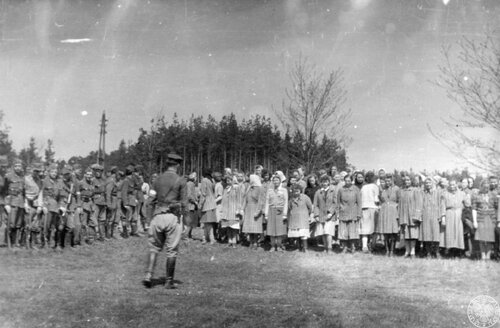 Żołnierze Brygady Świętokrzyskiej NSZ (po lewej) i grupa uwolnionych więźniarek (po prawej) z wyzwolonego 5 maja obozu w Holýšovie (niem. Holleischen) - filii obozu koncentracyjnego KL-Flossenburg w podczas apelu [?], autor: nieznany, 5 V 1945 r. Fot. AIPN