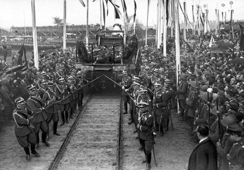 Pożegnanie Józefa Piłsudskiego z armią na Polu Mokotowskim w Warszawie; generałowie ciągną platformę kolejową, na której złożono trumnę z ciałem Marszałka, w kierunku Dworca Głównego. 17 maja 1935 r. Ze zbiorów Narodowego Archiwum Cyfrowego