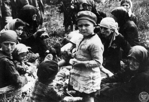 Grupa kobiet i dzieci z transportu Żydów z Węgier czeka na śmierć w pobliżu komór gazowych obozu zagłady KL Auschwitz II - Birkenau, maj 1944 r. Fot. z zasobu IPN