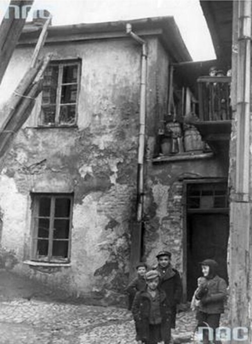 W marcu 1941 r. Niemcy utworzyli w okupowanym Krakowie getto (początkowo oficjalnie zamieszkiwało w nim ok. 11 tys. Żydów). Dzieci bawiące się na jednym z podwórek tej dzielnicy. Pozbawione dostępu do szkoły, często bez opieki rodziców, którzy zmuszeni byli pracować, dzieci wałęsały się w grupach i spędzały czas na ulicach getta. Ze zbiorów Narodowego Archiwum Cyfrowego