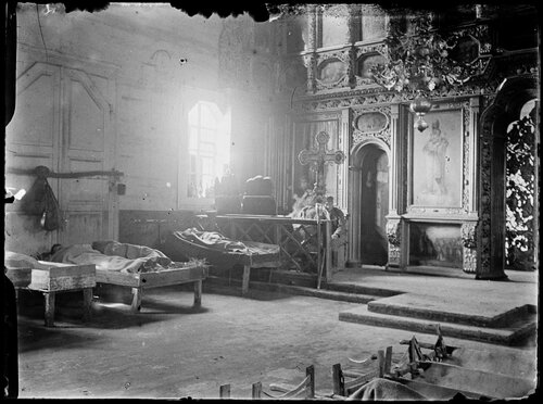 Dywizyjny Zakład Sanitarny w cerkwi w Piasecznej nad Stochodem, na tyłach frontu Legionów Polskich na Wołyniu, po ich wycofaniu znad Styru; lato 1916. Na zdjęciu wnętrze cerkwii, w której Austriacy urządzili lazaret polowy. Widoczny ikonostas z obrazem nieokreślonego świętego. Pod ścianą nary, wypełnione sianem lub słomą, z rannymi żołnierzami. Za barierką wysoki krzyż procesyjny i łożko z chorym, przy którym siedzi legionista. Autor: Stanisław Janowski. Ze zbiorów Muzeum Narodowego w Krakowie