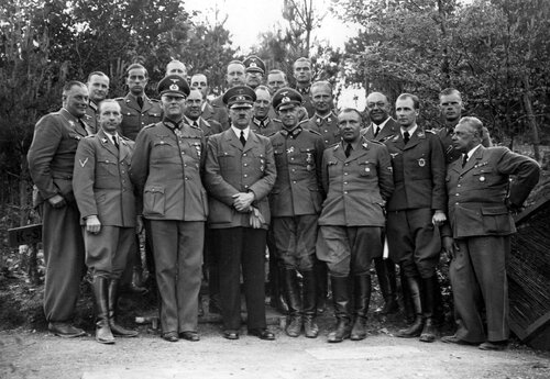 Adolf Hitler (trzeci z lewej, pierwszy rząd) ze swoim sztabem. Widoczni: Wilhelm Keitel (drugi z lewej, pierwszy rząd), Walther von Brauchitsch (czwarty z lewej, pierwszy rząd), Martin Bormann (piąty z lewej, pierwszy rząd). Czerwiec 1940. Ze zbiorów Narodowego Archiwum Cyfrowego