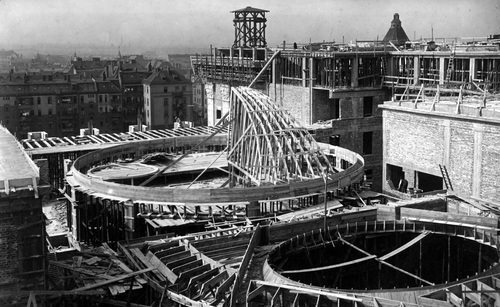 Budowa gmachu Sejmu Śląskiego i Urzędu Wojewódzkiego w Katowicach, wrzesień 1926 r. Etap wznoszenia górnych pięter i wznoszenia konstrukcji dachu. W oddali panorama miasta.