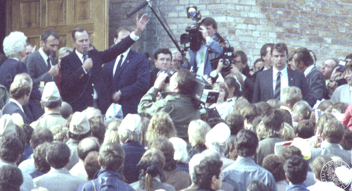 Tłum przed kościołem pw. Św. Małgorzaty w Łomiankach. Po środku przemawia wiceprezydent George Bush. Zdjęcie operacyjne SB. 27 września 1987 r.  (fotografia ze zbiorów IPN, sygn. IPNBU-3-11-1-710)