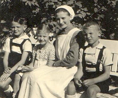 Siostra siedząca z trójką dzieci na ławce w parku.