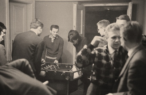 Grupa młodych ludzi w jednej z sal klubu "Hybrydy" w Warszawie. Widoczni mężczyźni grający w "piłkarzyki", lata 60. Fot. NAC