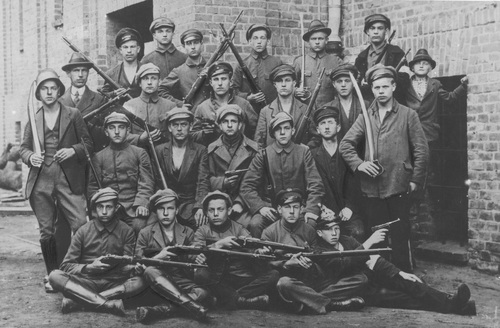 Grupa powstańców uzbrojonych w karabiny i szable oraz pistolety Parabellum P-08. Fot. NAC