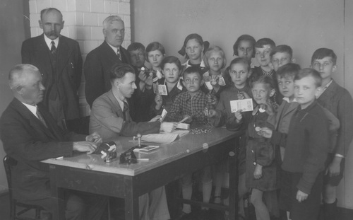 Dzieci ze szkoły powszechnej im. Tadeusza Kościuszki w Szczakowej dają datki pieniężne na Fundusz Obrony Narodowej, maj 1939 r. Fot. NAC
