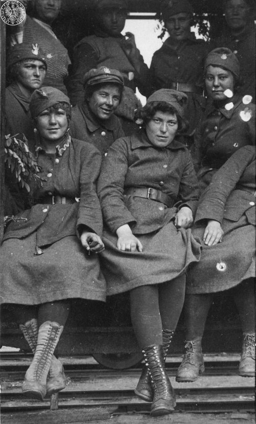 Grupa kobiet z Ochotniczej Legii Kobiet siedzi w wagonie kolejowym w drodze na front. Fot. AIPN