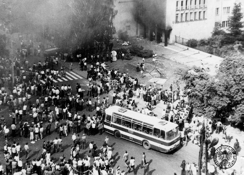 Radom, czerwiec 1976 r. Autobus zatrzymany przez protestujących robotników na ul. 1 Maja. W głębi widoczne osmolone wejście do gmachu Komitetu Wojewódzkiego PZPR. Fot. z zasobu IPN