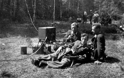 Lasy Janowskie, sierpień 1950 r. Przy dostarczonej przez UB radiostacji leżą od lewej: Adam Kusz „Garbaty”, Tadeusz Parylak „Czarny”, Tadeusz Haliniak „Opium”