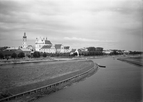 Pińsk, panorama miasta z widokiem na rzekę Pinę, 1936 rok. Nabrzeże porośnięte drzewami. Widoczne jasne mury kościoła i kamienic oraz wysoka wieża.