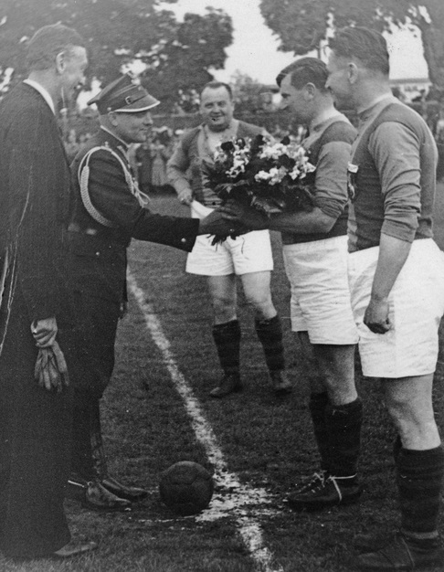 Major Zemanek wręcza kwiaty Wacławowi Kucharowi przed meczem piłki nożnej Pogoń-Cracovia rozegranym na jubileuszu 35 lecia Pogoni, w którym starsi piłkarze grali przez 15 minut, czerwiec 1939 r. Fot. NAC