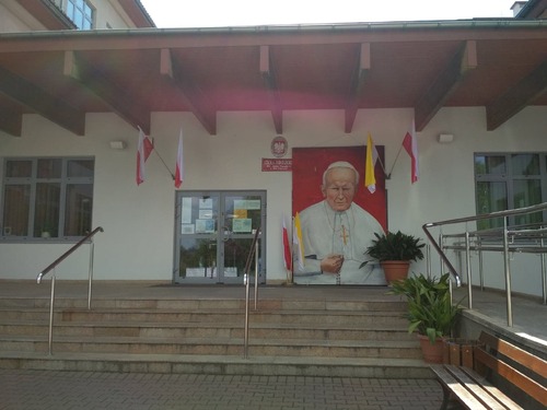 Wejście do Szkoły Podstawowej im. Jana Pawła II w Zielonkach przyozdobione z okazji 100. rocznicy urodzin patrona - maj 2020 r. (fot. ze strony internetowej placówki)
