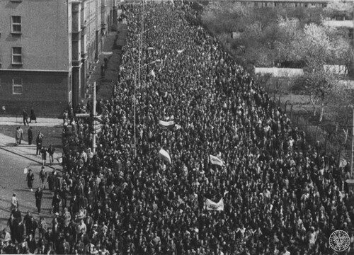 1 maja 1982 r., Szczecin, Polacy maszerujący w demonstracji pod polskimi flagami ul. Ku Słońcu. Fot. z zasobu IPN