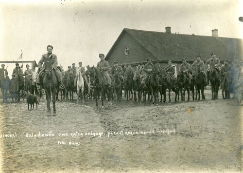 Oddział kawalerii Stanisława Bułaka-Bałachowicza (siedzącego na koniu, obok którego stoi pies Wright), październik-listopad 1919 rok. Żołnierze noszą umundurowanie wzoru rosyjskiego. W tle zabudowania.