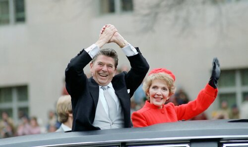 Prezydent Ronald Reagan z żoną, Nancy, machający Amerykanom z limuzyny podczas parady inauguracyjnej w dniu rozpoczęcia pierwszej kadencji prezydenckiej, Waszyngton, 20 stycznia 1981. Fot. Wikimedia Commons/domena publiczna