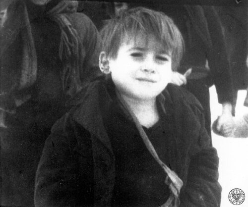 Chłopiec - jeszcze przed kilkoma chwilami więzień obozu koncentracyjnego Auschwitz-Birkenau. Po oswobodzeniu obozu przez Armię Czerwoną, 27 stycznia 1945 r. Reprodukcja kadru z sowieckiej kroniki filmowej. Fot. z zasobu IPN
