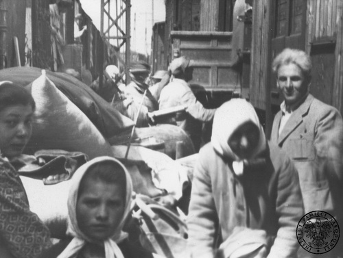 Przesiedleńcy na jednej ze stacji kolejowych. Fotografia z albumu Państwowego Urzędu Repatriacyjnego, 1945-1946 r. Fot. AIPN