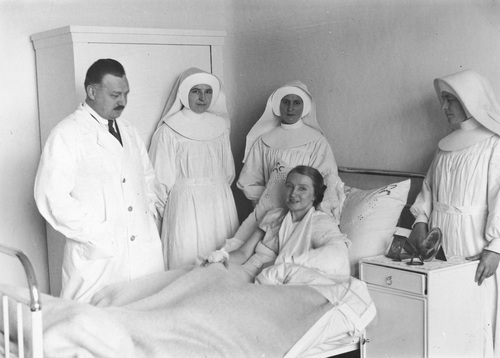 Pobyt Hanki Ordonówny po wypadku samochodowym w szpitalu w Warszawie. Artystka ze złamanym obojczykiem leży na łóżku szpitalnym w otoczeniu sióstr elżbietanek i lekarza, 1931 r. Fot. NAC