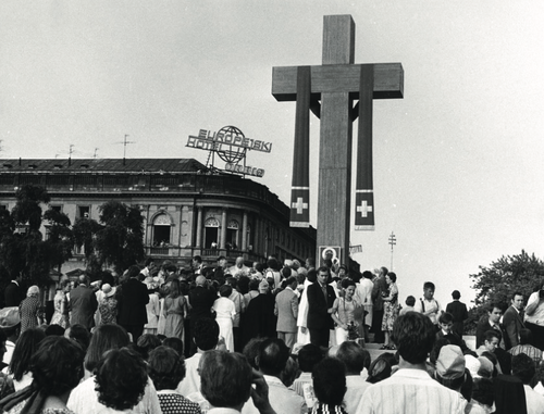 Tłum przed ołtarzem polowym z wysokim i masywnym drewnianym krzyżem