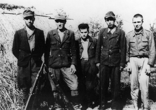 Pięciu mężczyzn ustawionych do zdjęcia z elementami charakterystycznego umundurowania