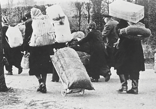 Grupa idących ludzi z bagażami