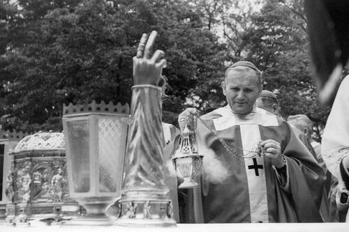Biskup Karol Wojtyła okadzający wystawione na ołtarzu relikwie.