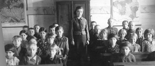 Zdjęcie młodych uczennic siedzących w ławkach szkolnych