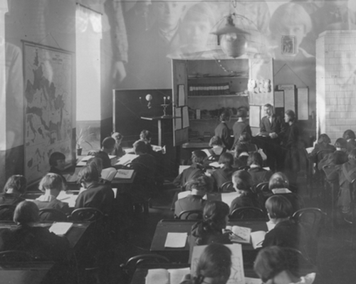 Zdjęcie młodych uczennic siedzących w ławkach szkolnych
