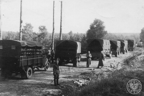 Ciężarówki stojące na drodze; wzdłuż drogi stoją niemieccy żołnierze