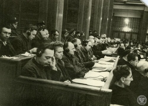 Byli członkowie załogi KL Auschwitz-Birkenau siedzą na ławie oskarżonych w czasie procesu przed Najwyższym Trybunałem Narodowym w Krakowie - widok ogólny z boku. Na uszach mają słuchawki