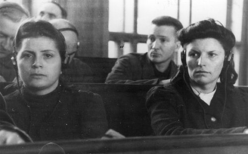 Byłe nadzorczynie w KL Auschwitz II Birkenau Luise Danz i Hildegard Lächert siedzą na ławie oskarżonych - zbliżenie od przodu. Na uszach mają słuchawki