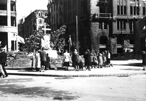 Ludność zgromadzona wokół ołtarza ulicznego ustawionego przed gmachem Banku Towarzystw Spółdzielczych - Warszawa, 1 sierpnia 1945 r. Fot. Wacław Żdżarski (NAC)