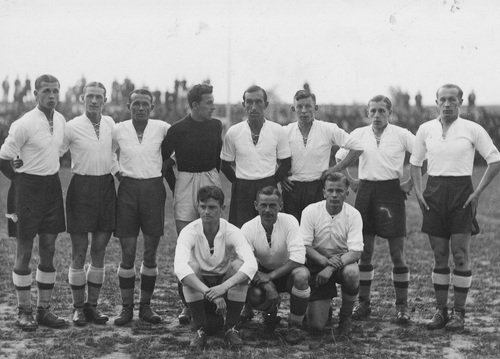 Jedenastka piłkarzy pozująca do zdjęcia na murawie stadionu.