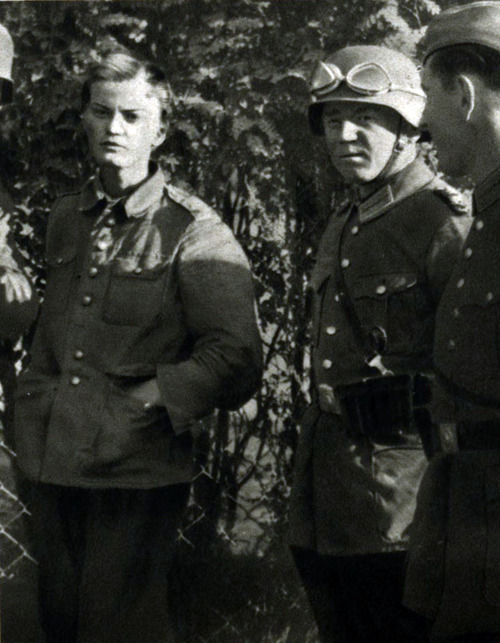 Wzięta do niewoli niemieckiej Polka w bluzie mundurowej, ale bez czapki wojskowej. Obok żołnierze niemieccy. Zdjęcie to znalazło się w jednym z niemieckich wojennych wydawnictw ilustrowanych o kampanii 1939 roku z karykaturalnym opisem opisującym Wojsko Polskie jako niepełnowartościowego przeciwnika. Tego typy stereotypy były jednymi z przyczyn zbrodni wojennych.
