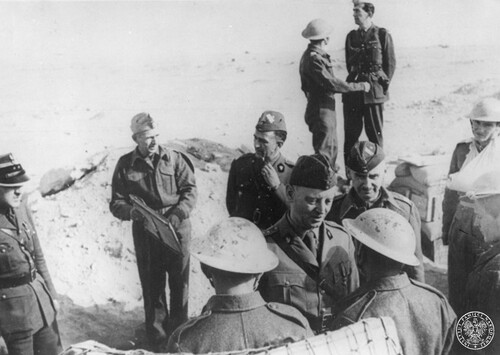 Żołnierze noszą brytyjskie hełmy Mk.II (tzw. hełmy Brodiego), oficerowie i generałowie polskie furażerki, a jeden z oficerów (po lewej, najprawdopodobniej szef Oddziału III Operacyjnego Sztabu Naczelnego Wodza ppłk dypl. Andrzej Marecki) nosi czapkę polową wz. 37 tzw. rogatywkę z usztywnianym denkiem (otok prawdopodobnie granatowy oznaczający oficera sztabowego)