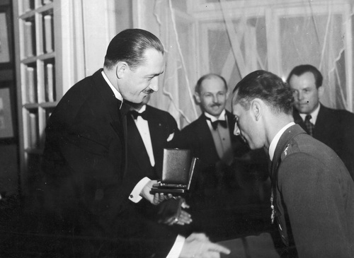 Wojciech Kołaczkowski odbiera nagrodę z rąk prezesa Automobilklubu Polski wiceministra komunikacji Juliana Piaseckiego za udział w X Międzynarodowym Rajdzie Samochodowego Automobilklubu Polski, czerwiec 1937 r. Fot. NAC