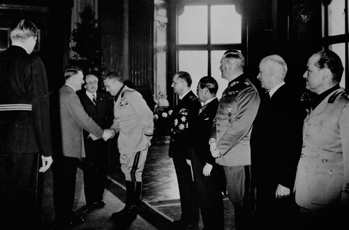 Przystąpienie Węgier do Paktu Trzech, Wiedeń, 20 listopada 1940 r. Adolf Hitler wita się z przedstawicielami państw, które przystąpiły do Paktu. Widoczni od lewej: Pál Teleki (w okularach), ministrowie spraw zagranicznych - Włoch Galeazzo Ciano i Węgier István Csáky, dalej - Saburo Kurusu (ambasador Japonii w Niemczech), feldmarsz. Wilhelm Keitel (szef Naczelnego Dowództwa Wehrmachtu) i Döme Sztójay (ambasador Węgier w Niemczech). Ze zbiorów NAC (autor zdjęcia: Heinrich Hoffmann)