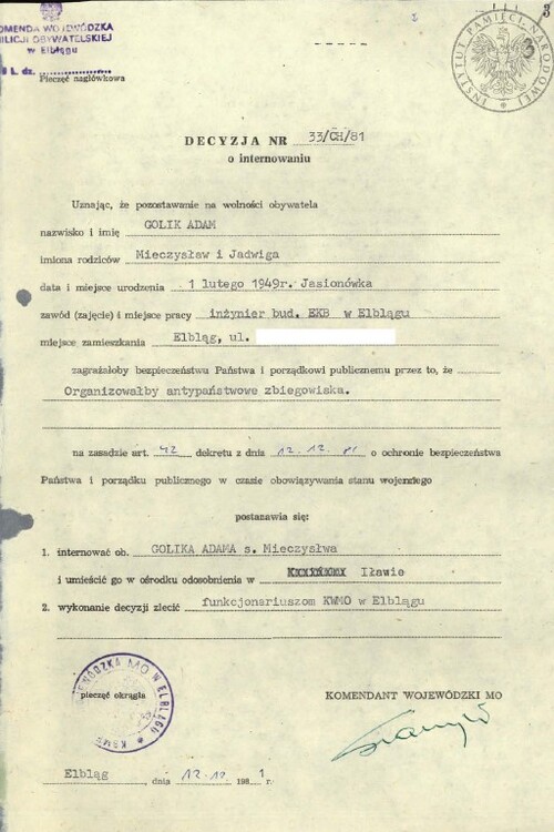 Decyzja o internowaniu Adama Golika. Fotokopia blankietu dokumentu decyzji o internowaniu wypełnionego maszynowo danymi dotyczącymi Adama Golika, w tym uzasadnieniem o internowaniu o brzmieniu: „organizowałby antypaństwowe zbiegowiska”. Jako miejsce internowania jest tu wskazany „ośrodek odosobnienia” w Iławie. Dokument nosi datę 12 grudnia 1981 roku, miejscem jego podpisania jest Elbląg, a został podpisany przez Komendanta Wojewódzkiego Milicji Obywatelskiej w Elblągu. Na dokumencie są między innymi odciski pieczęci Komendy Wojewódzkiej Milicji Obywatelskiej w Elblągu.