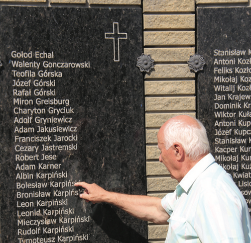 Czesław Karpiński pokazuje nazwisko swojego ojca na tablicy upamiętniającej Polaków z Dołbysza wymordowanych przez NKWD (fot. Michał Masłowski)